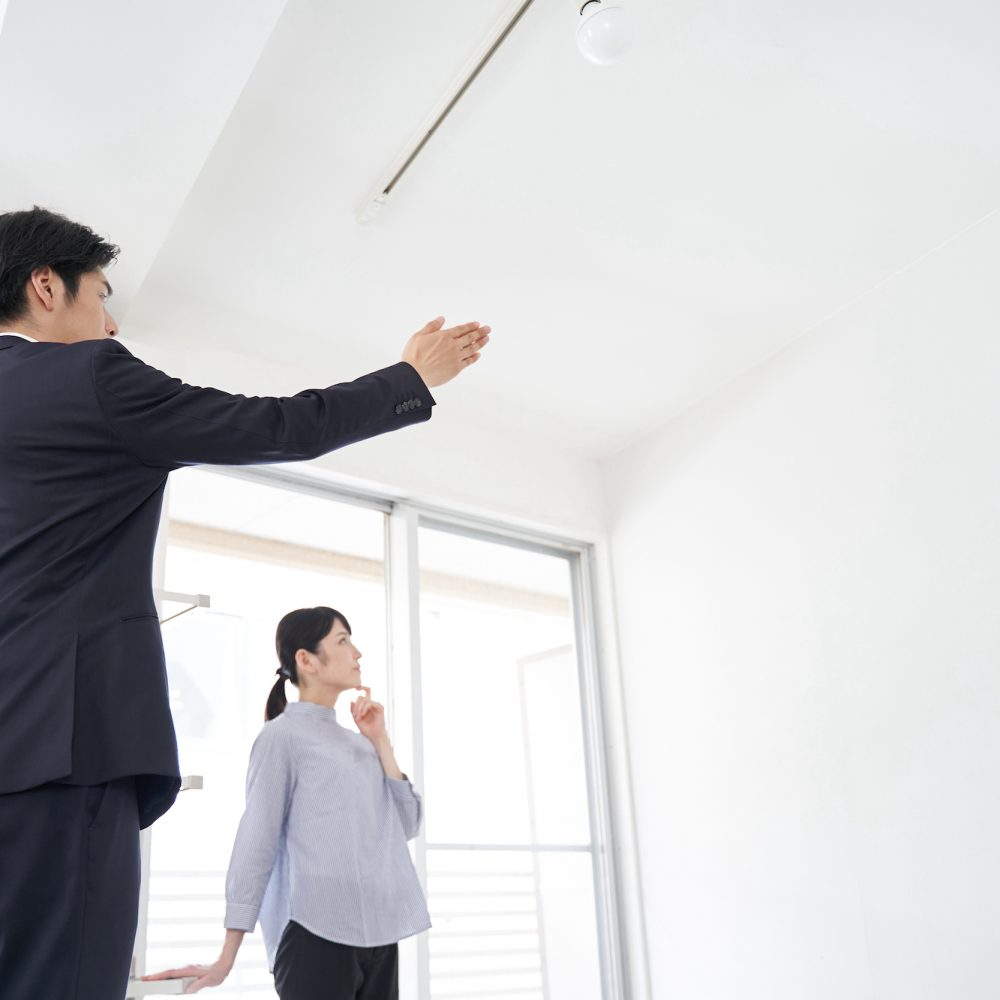 A Japanese male real estate salesman showing a house