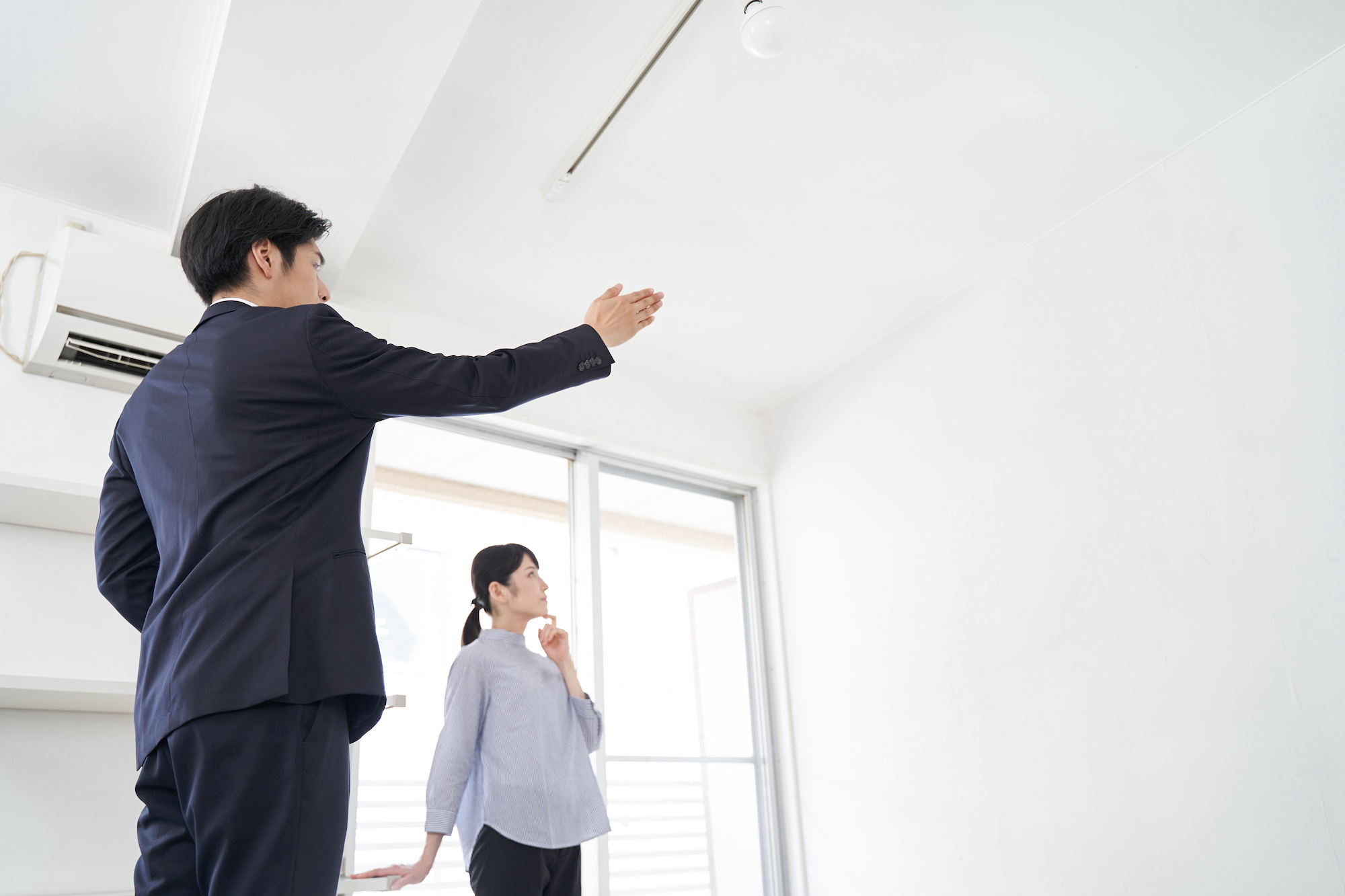 A Japanese male real estate salesman showing a house